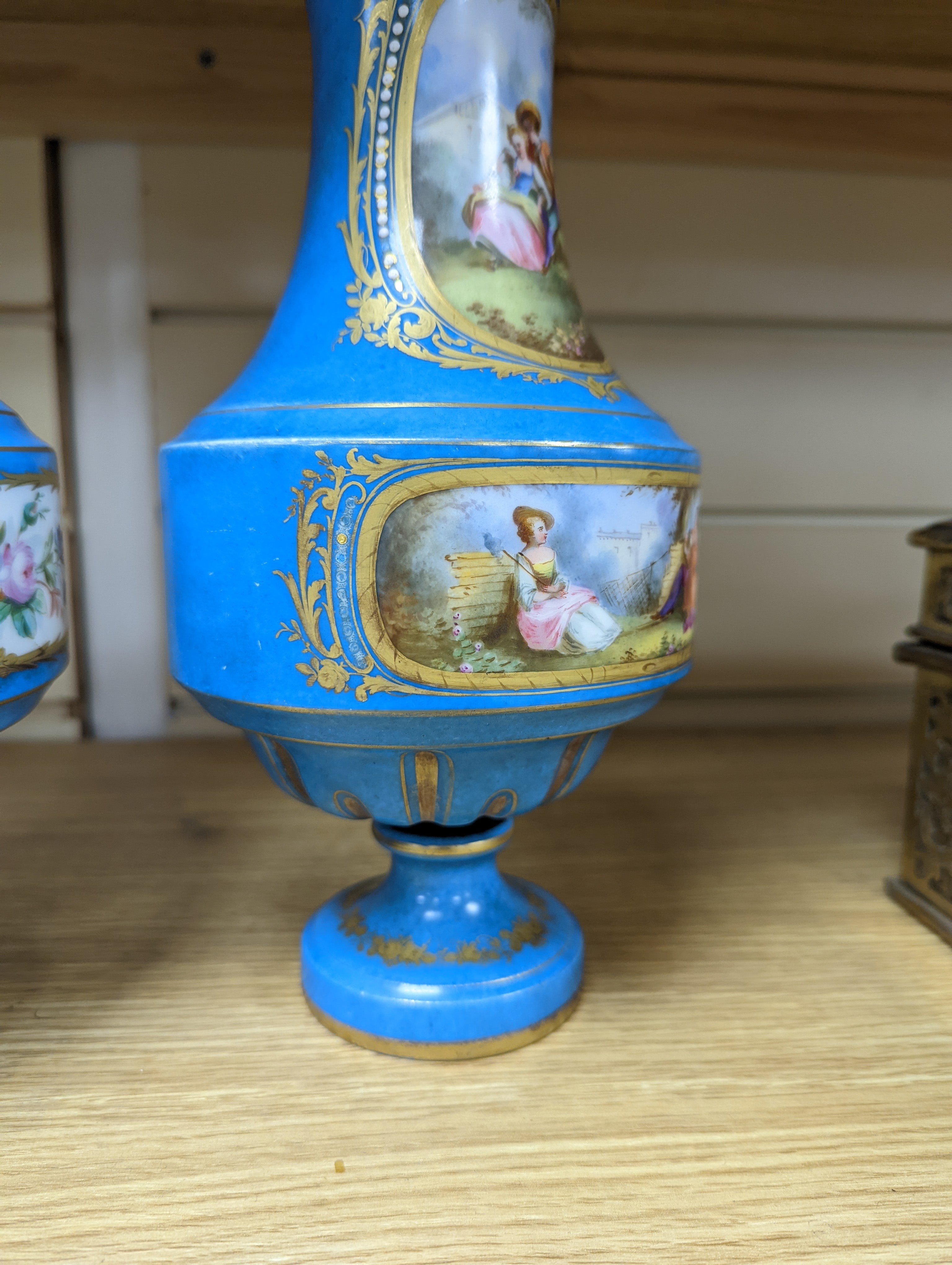A pair of Sevres style porcelain bleu celeste ground vases and covers, 34cm